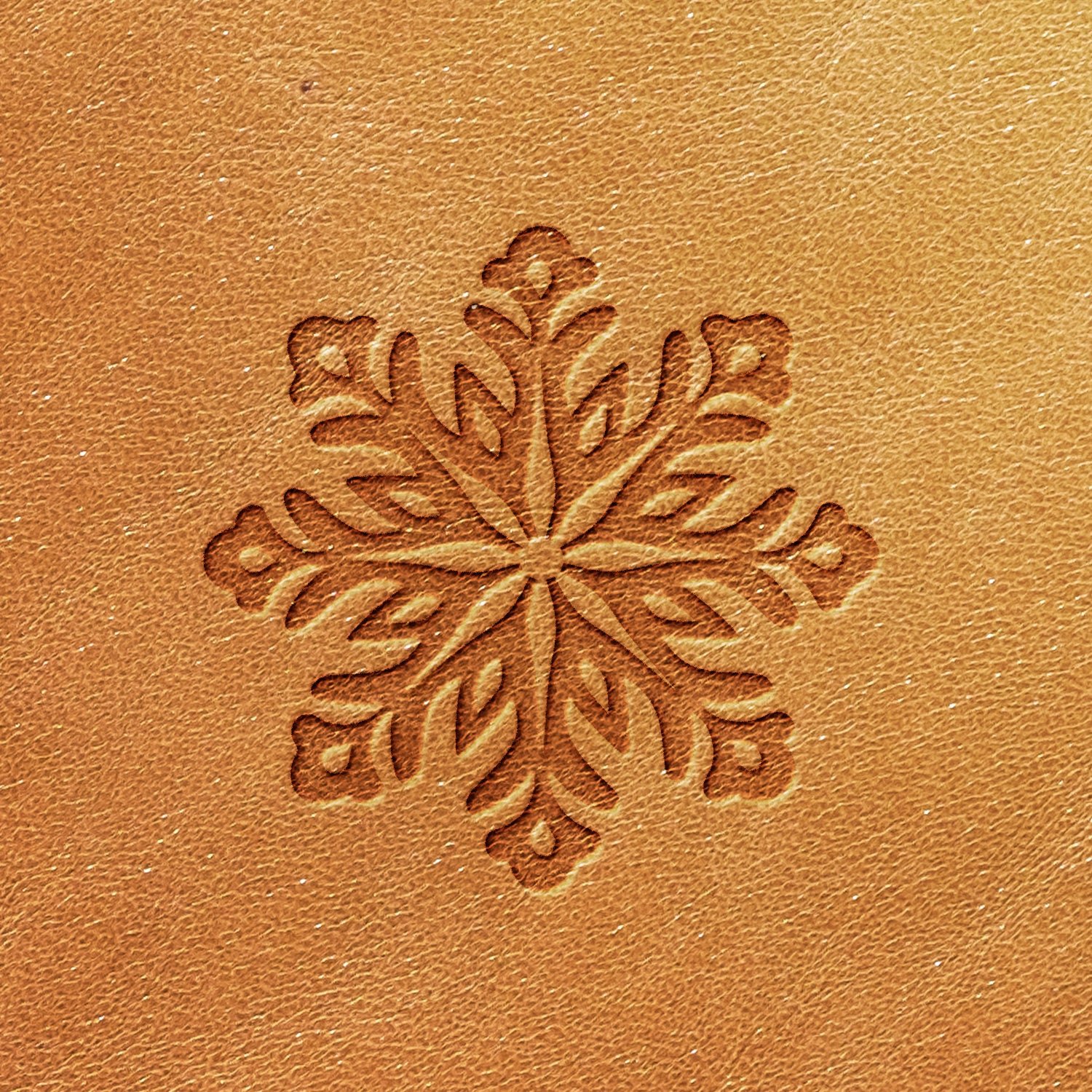 The Snowflake Delrin Leather Stamp features a detailed snowflake design on brown leather, showcasing symmetrical patterns that create a decorative and textured appearance.