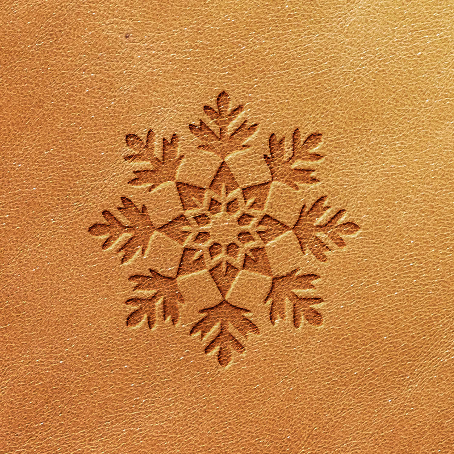 The Snowflake Delrin Leather Stamp intricately etches a symmetrical snowflake pattern on your brown leather, showcasing multiple branches and shapes radiating from the center in a stunning array of geometric artistry.