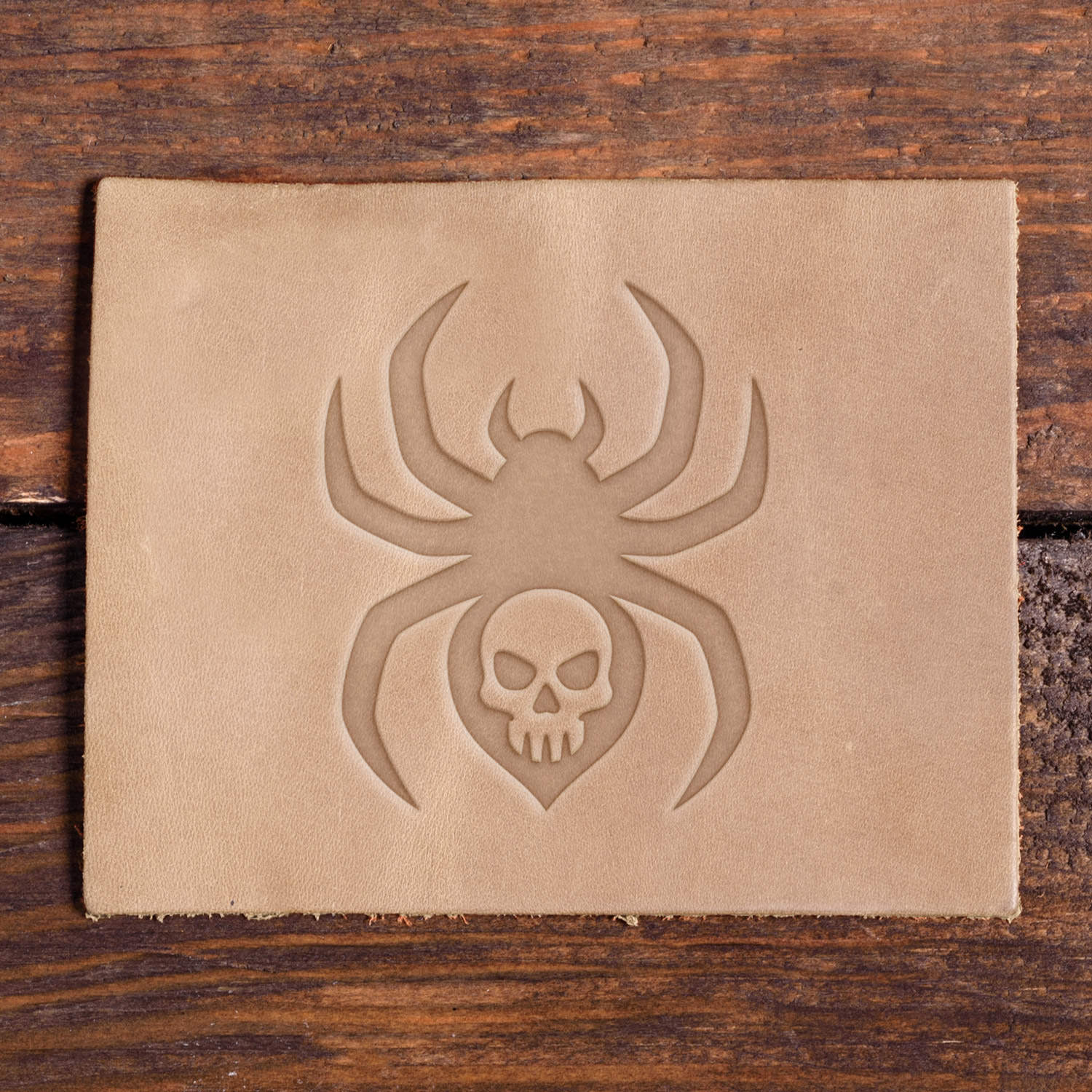 Spider with skull design stamped into natural veg-tan leather using a Delrin leather stamp.