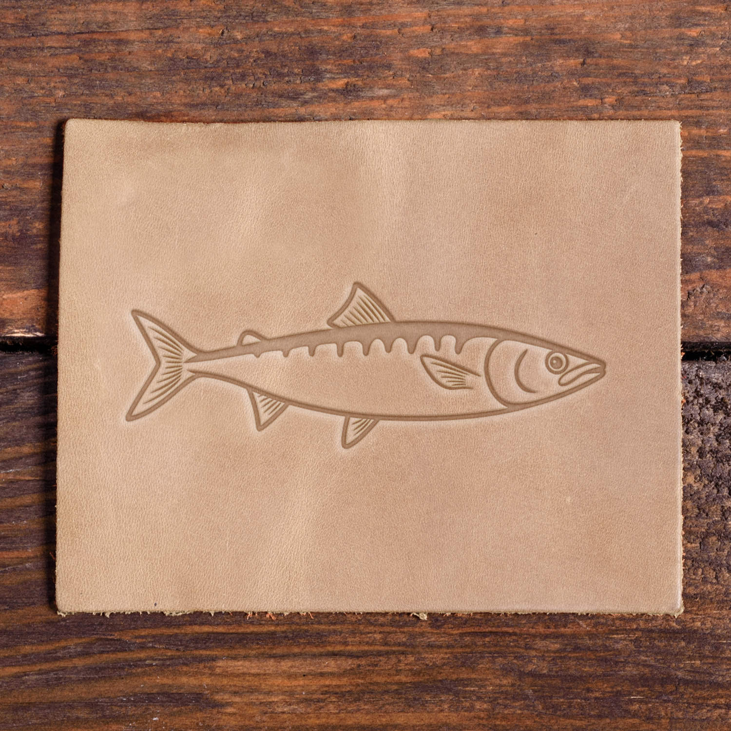 Leather sample showcasing a stamped sardine fish design using a Delrin leather stamp.