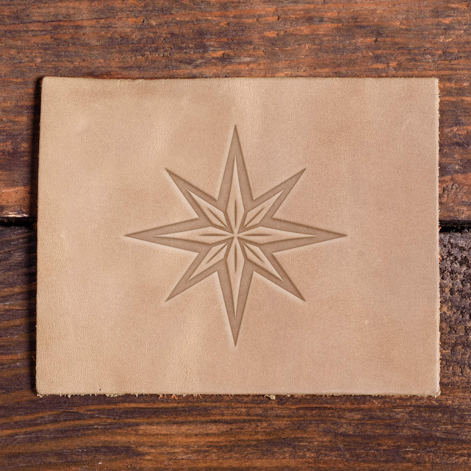 Leather sample with a stamped compass star design using a Delrin leather stamp, ideal for nautical or adventure-themed leather projects.