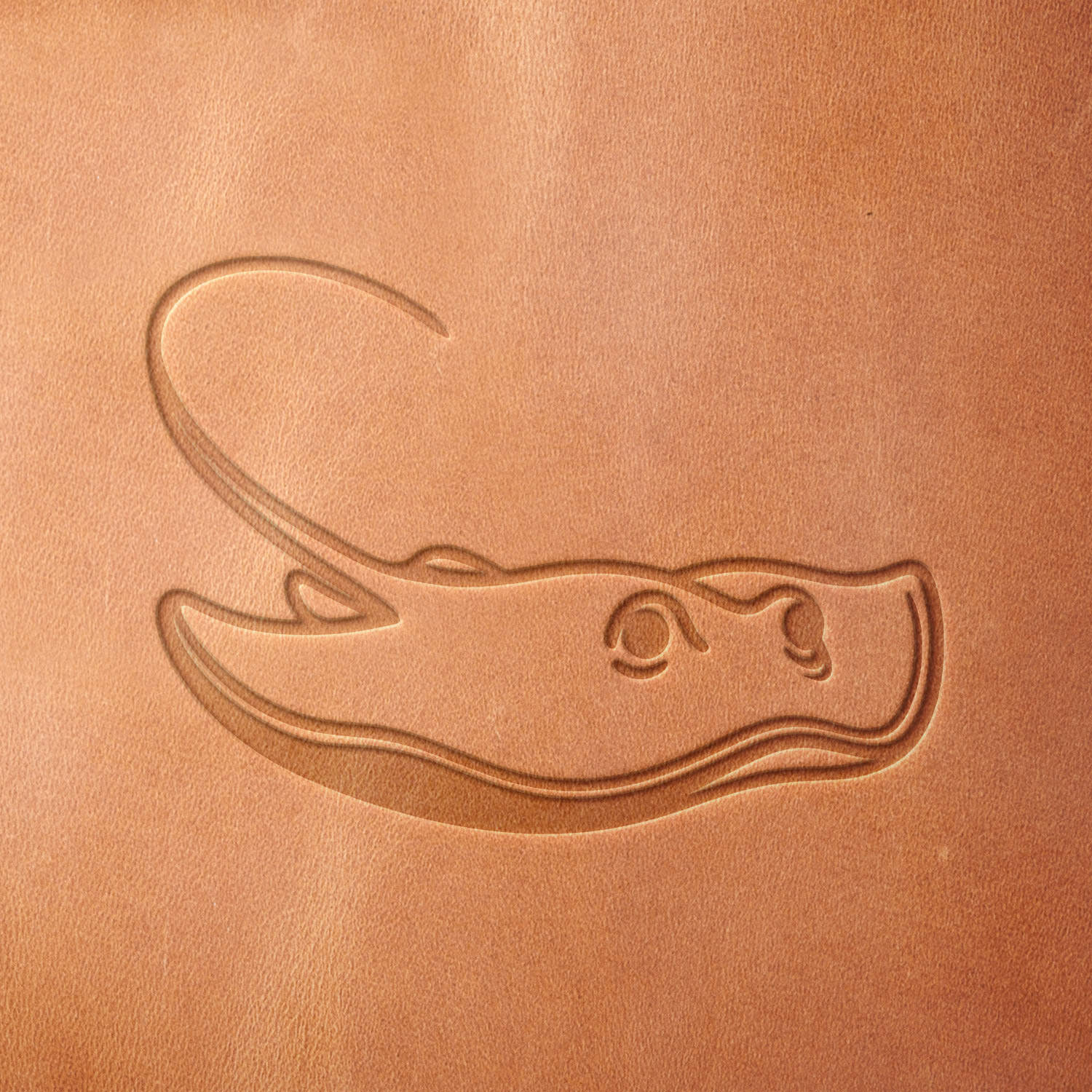 Leather sample showcasing a stamped stingray design using a delrin leather stamp, emphasizing the stingray’s flowing silhouette and distinctive tail.