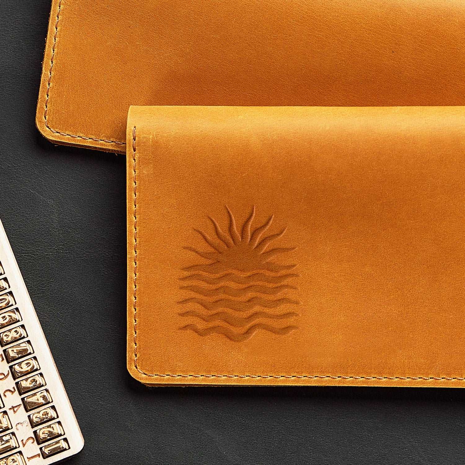 Leather wallet featuring a sun over waves design stamped with a Delrin tool, perfect for creating ocean and beach-themed leather crafts