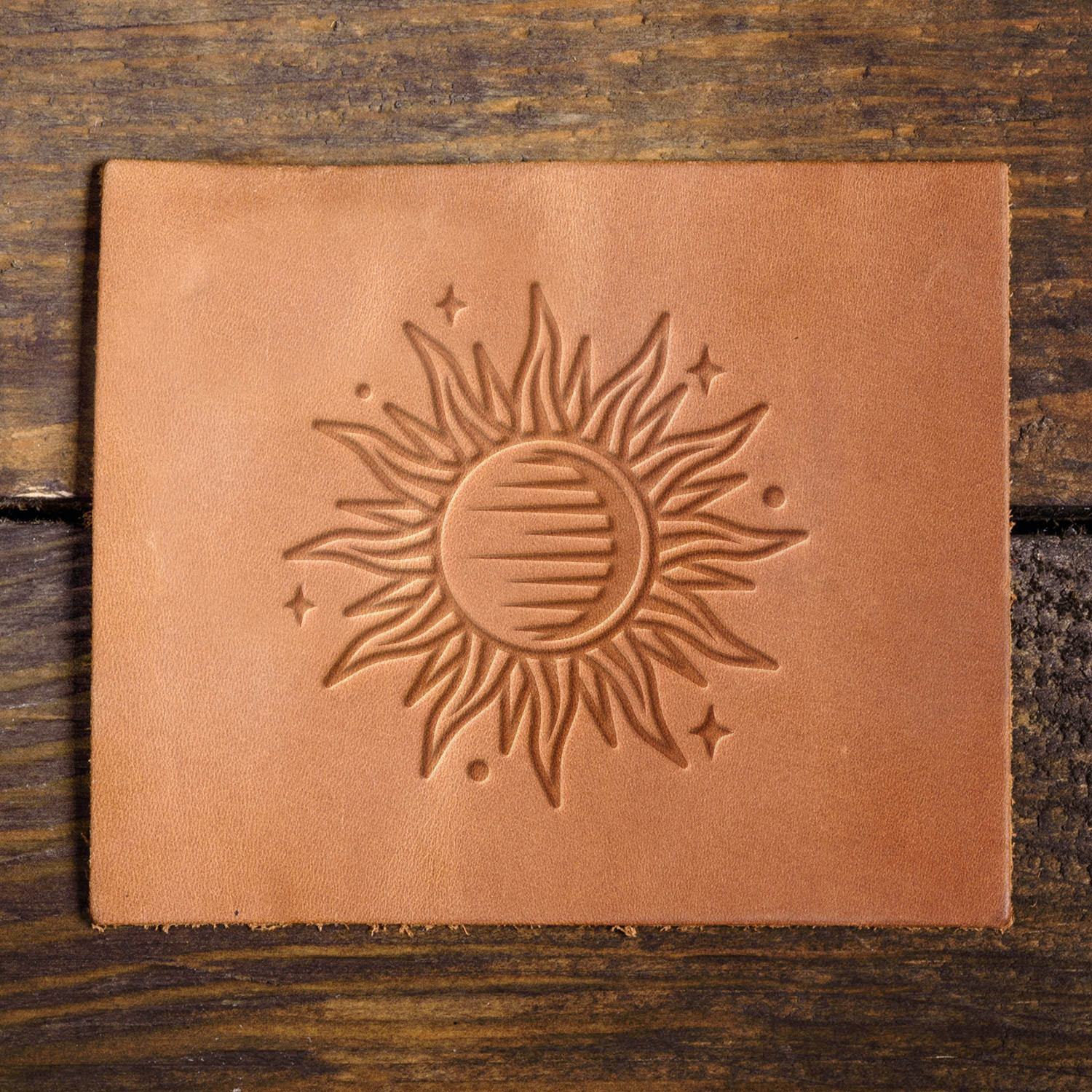 Leather sample featuring a stamped sun with artistic rays, adding a celestial touch to leather projects.