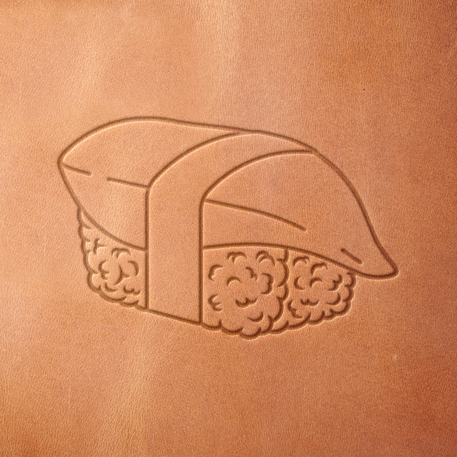Leather piece stamped with a Delrin leather stamp of a sushi nigiri—great for adding a fun culinary touch to aprons, wallets, or custom leather menus.