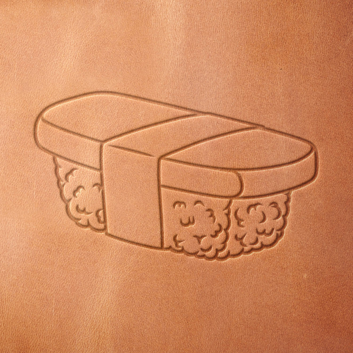 Leather piece stamped with a Delrin leather stamp of tamago sushi—adds a playful and delicious detail to kitchen goods, leather menus, or chef-themed gifts.