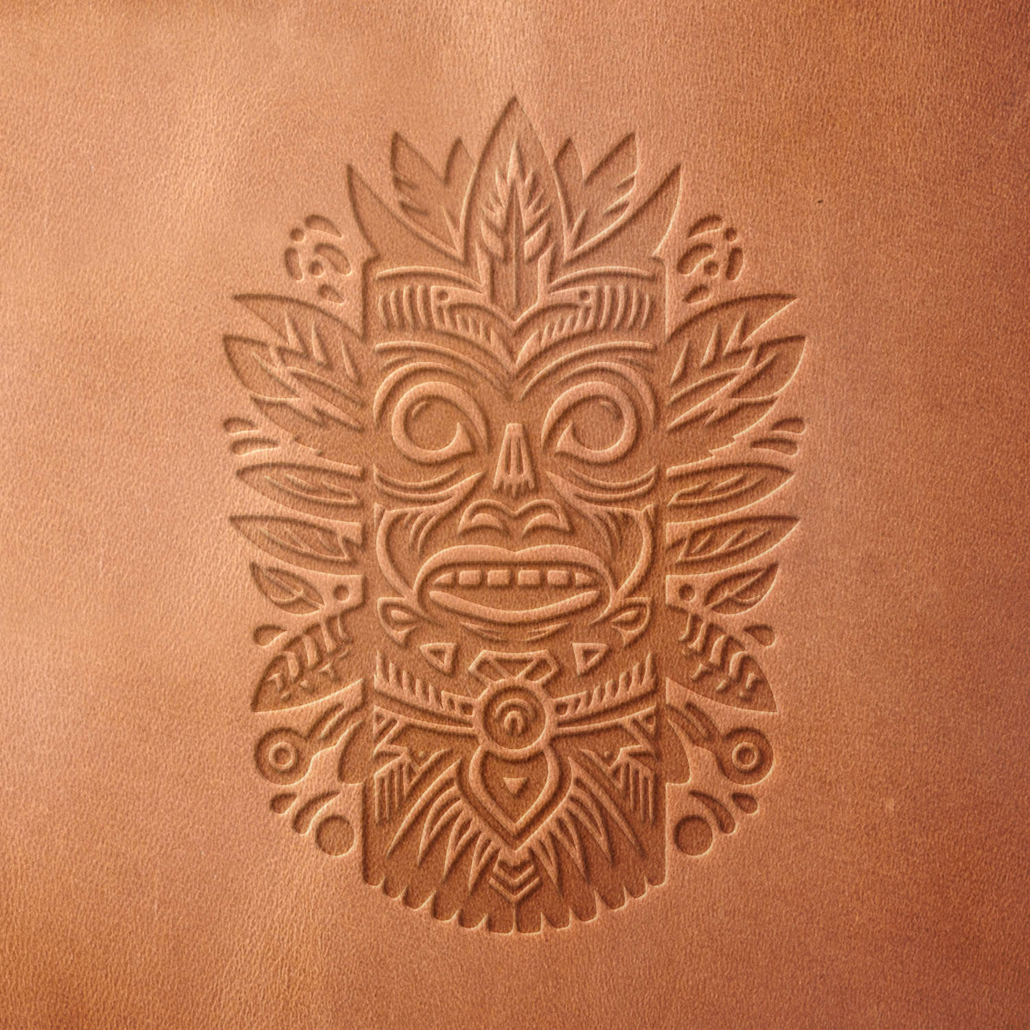 Leather sample with a crisp tribal mask stamp impression from a Delrin leather stamp, ideal for creating high-quality cultural and decorative-themed leathercraft projects.