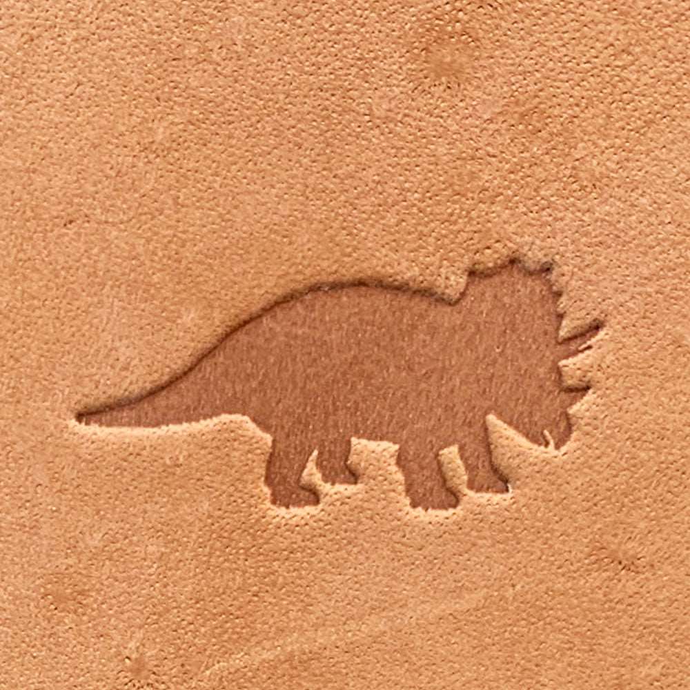 Natural veg-tan leather stamped with a triceratops silhouette using a Delrin leather stamp, showing bold prehistoric form and clean edges.