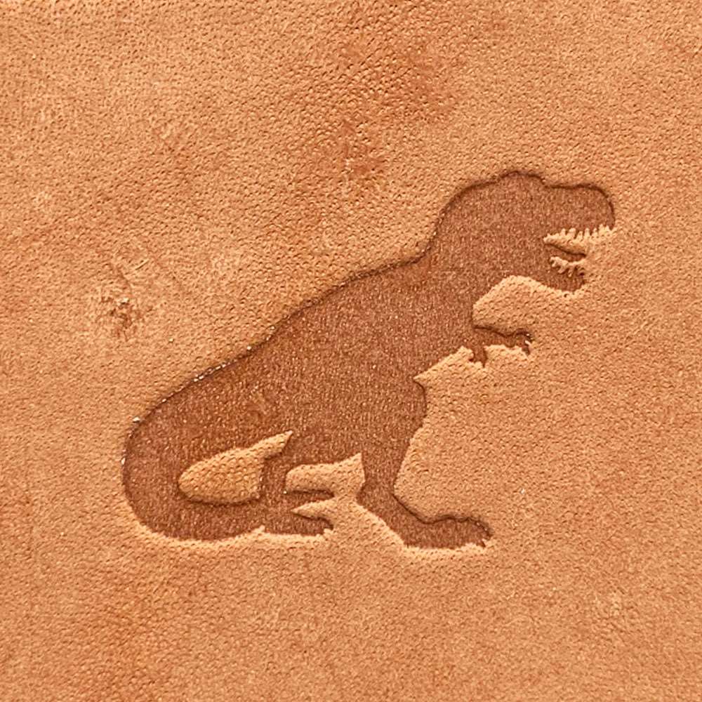 Natural veg-tan leather stamped with a Tyrannosaurus rex silhouette using a Delrin leather stamp, showing bold contours and strong prehistoric form.