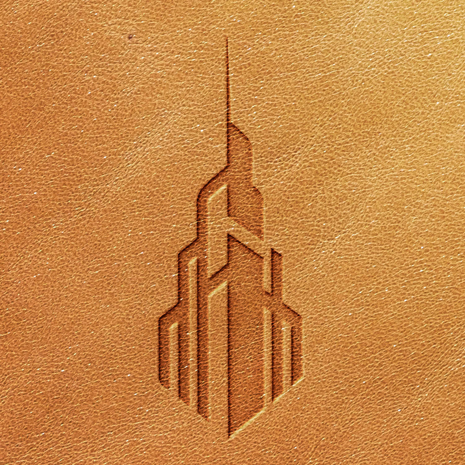 The Tower Delrin Leather Stamp showcases a stylized, embossed graphic of a skyscraper, set against a textured tan leather background. The design is characterized by angular lines and geometric shapes, imparting a modern, architectural appearance.