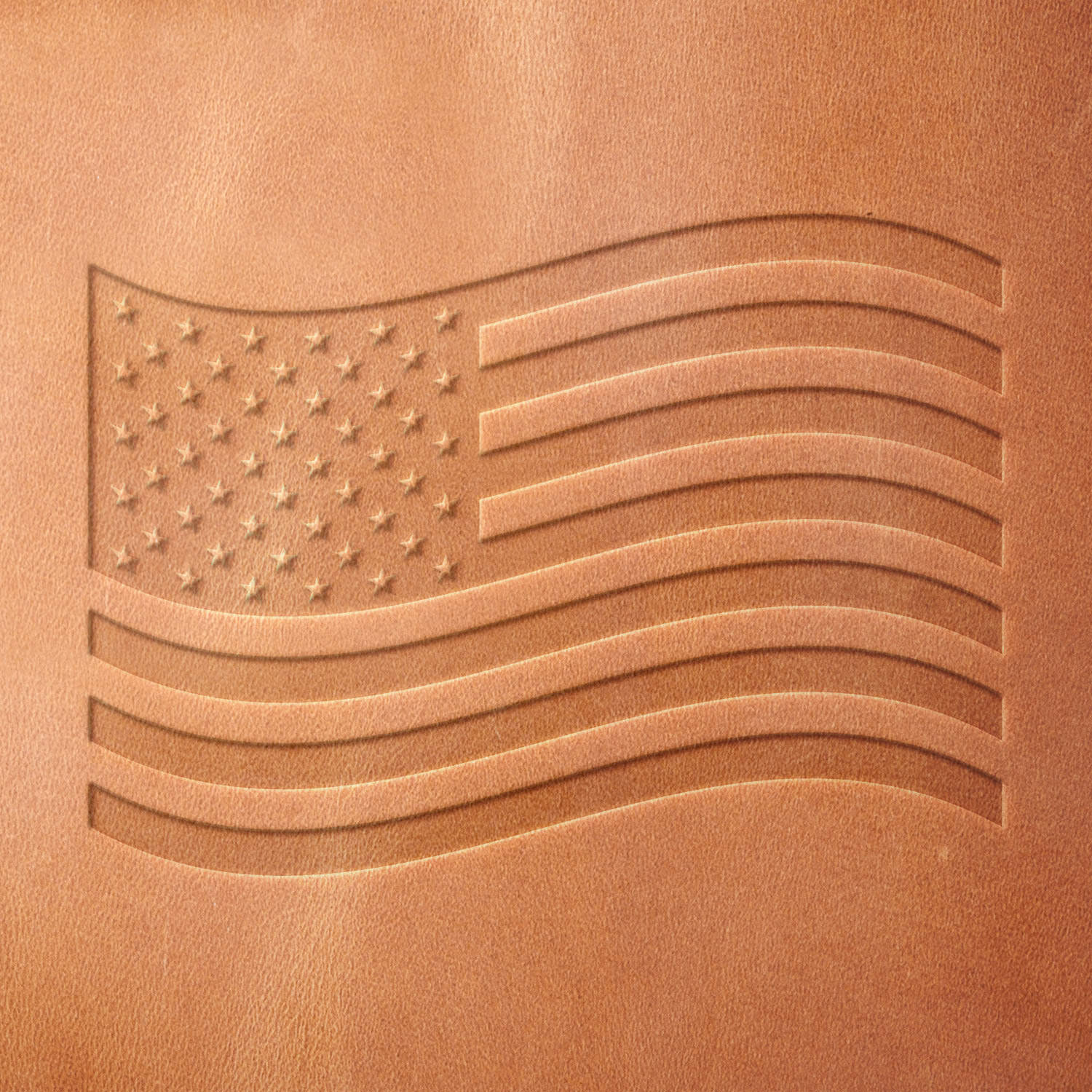 Leather sample showcasing a stamped American flag design using a delrin leather stamp, highlighting the flag’s flowing shape and distinct star-and-stripe pattern.