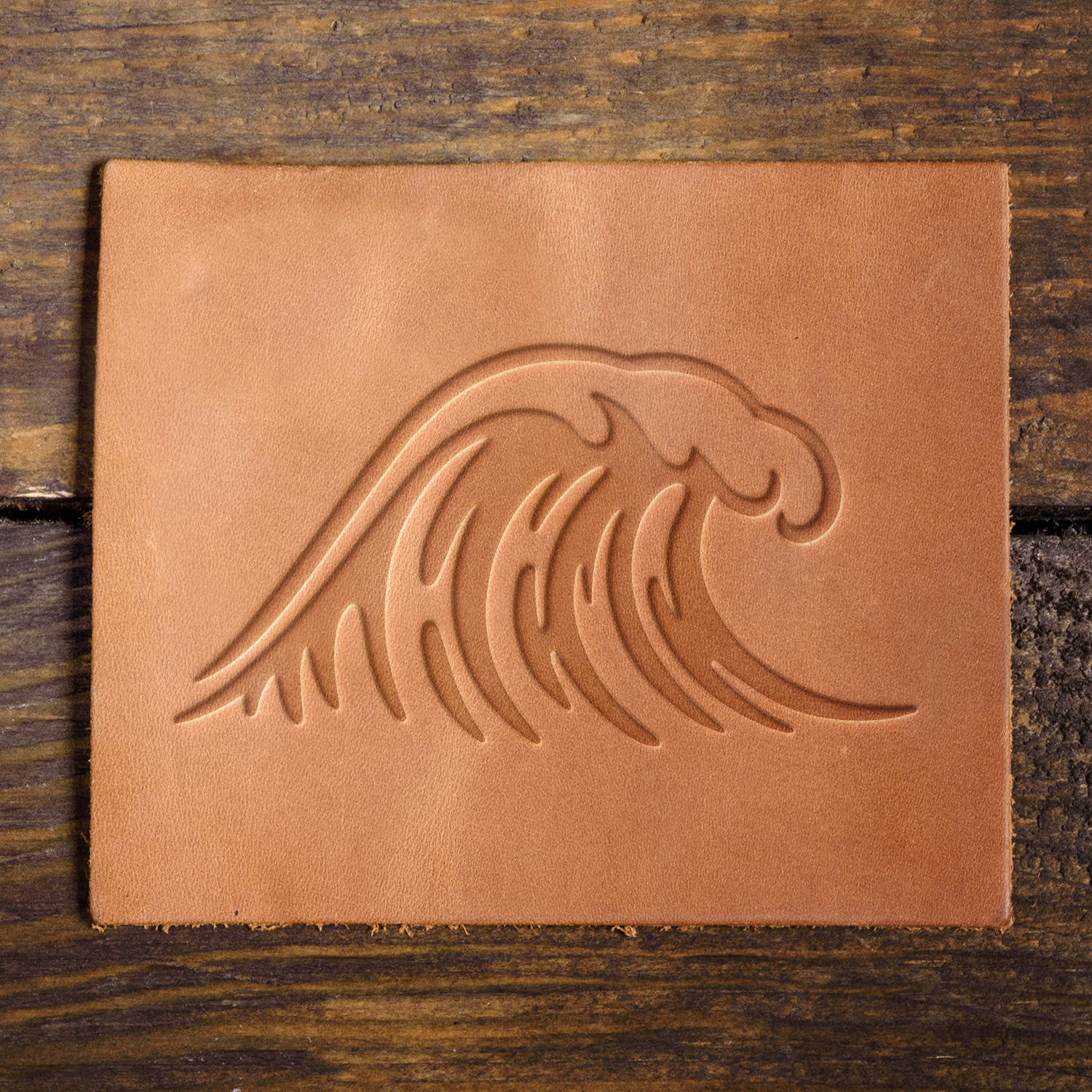 Leather sample featuring an embossed ocean wave, adding a dynamic touch to beach-inspired leather designs.