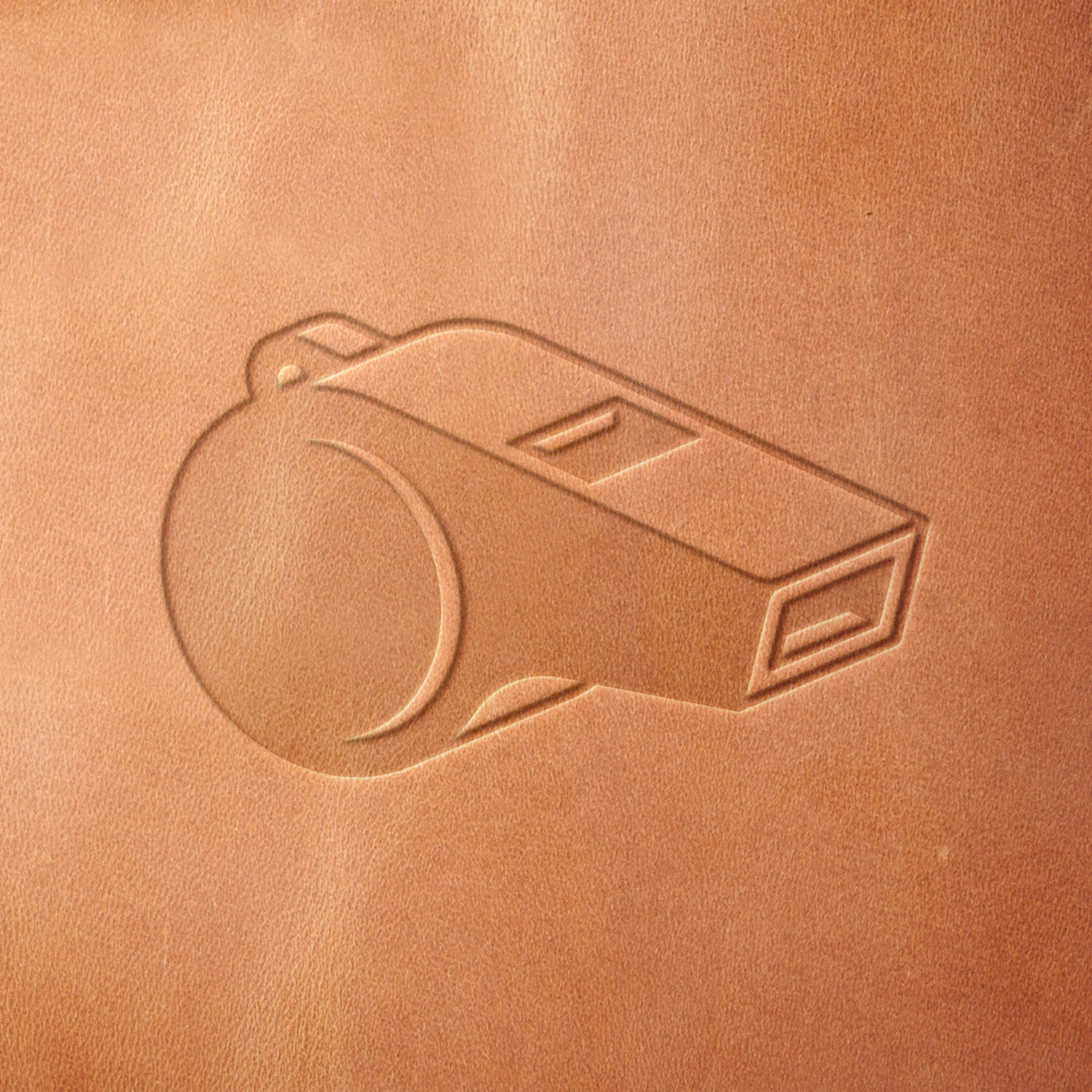 Leather sample showcasing a stamped sports whistle design using a delrin leather stamp, emphasizing the whistle’s sleek body and defined edges.