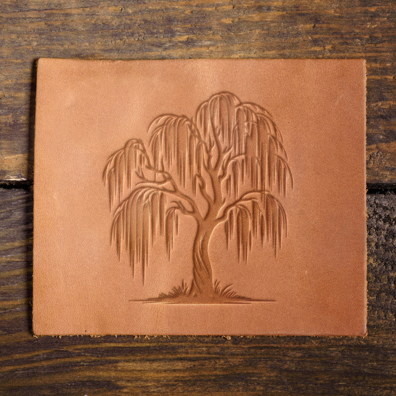 Leather sample with a detailed willow tree stamp impression, adding a touch of nature and elegance to leather projects.