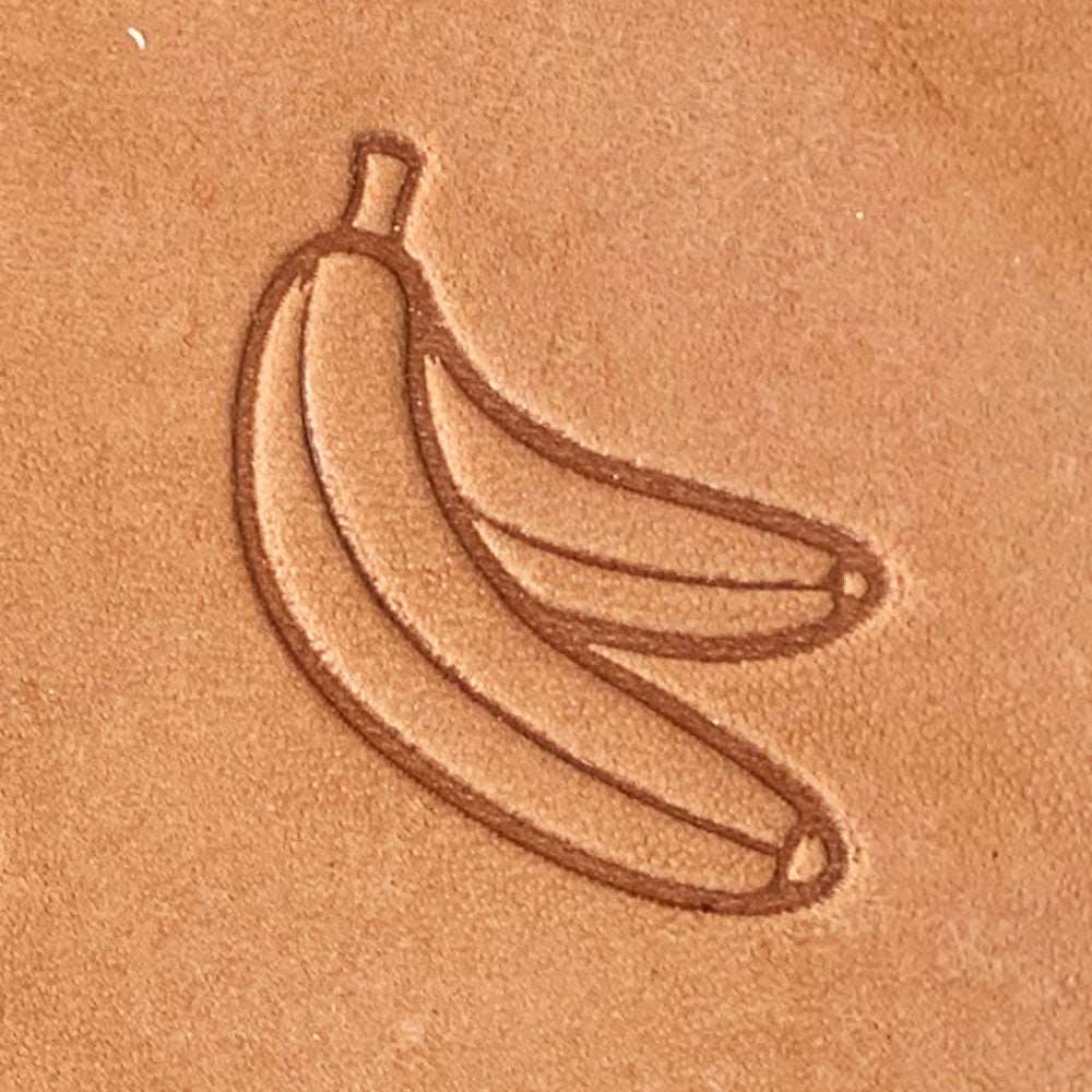 Natural veg-tan leather stamped with a peeled banana design using a Delrin leather stamp, showing smooth curves and clear outline detail.