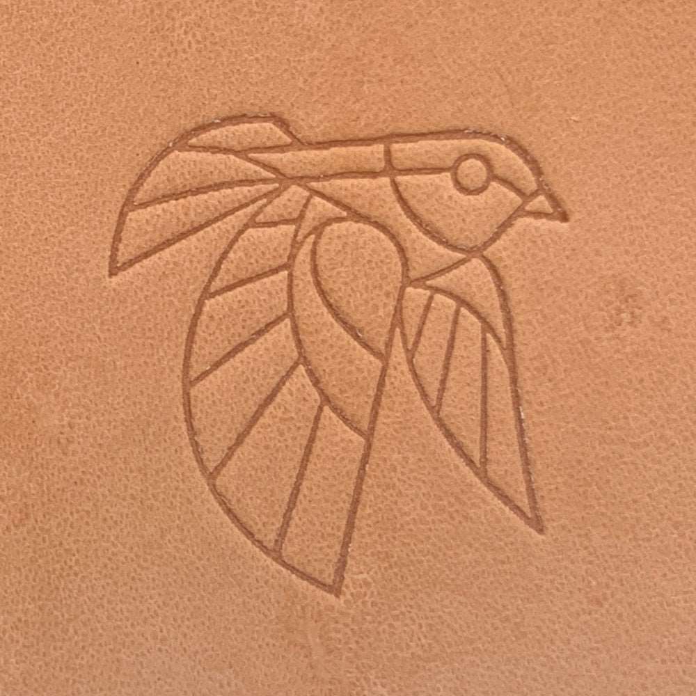 Stamped impression of a geometric bird made with a Delrin leather stamp on natural veg-tan leather.