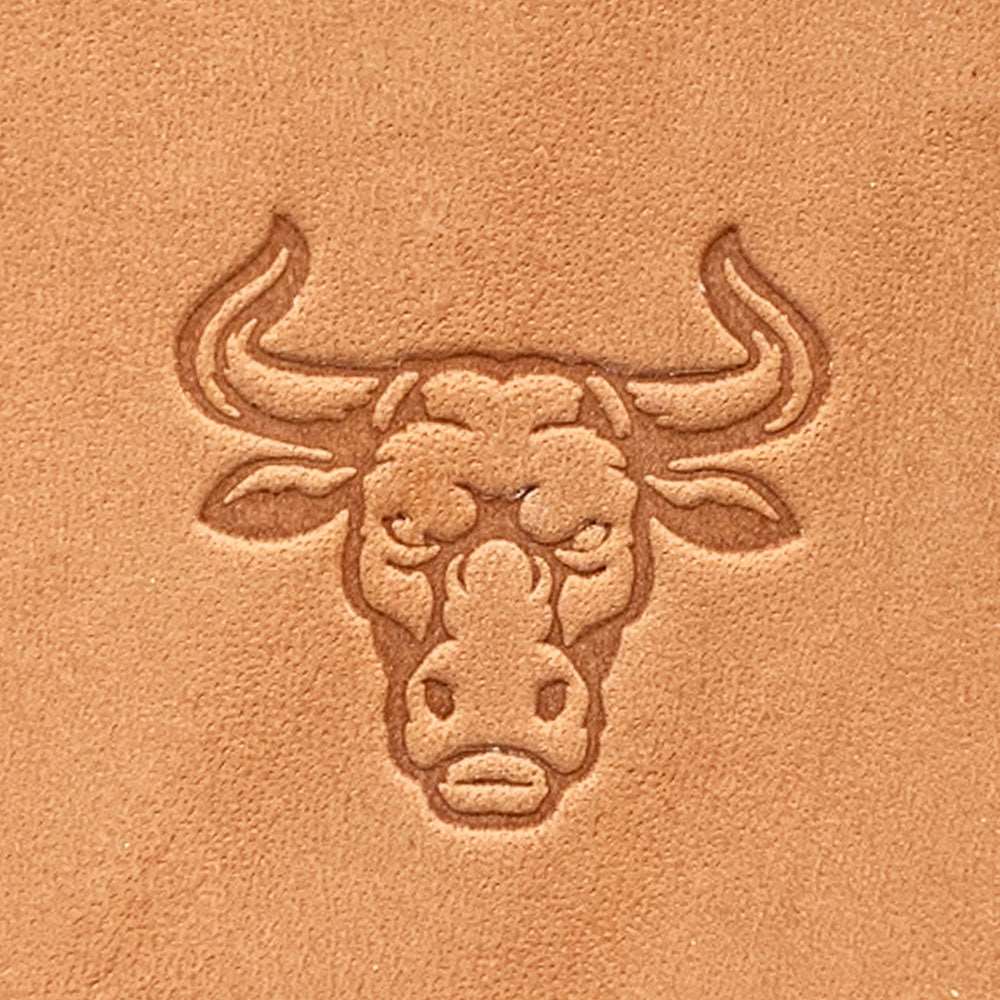 Stamped impression of a bull head with curved horns made using a Delrin leather stamp on natural veg-tan leather.