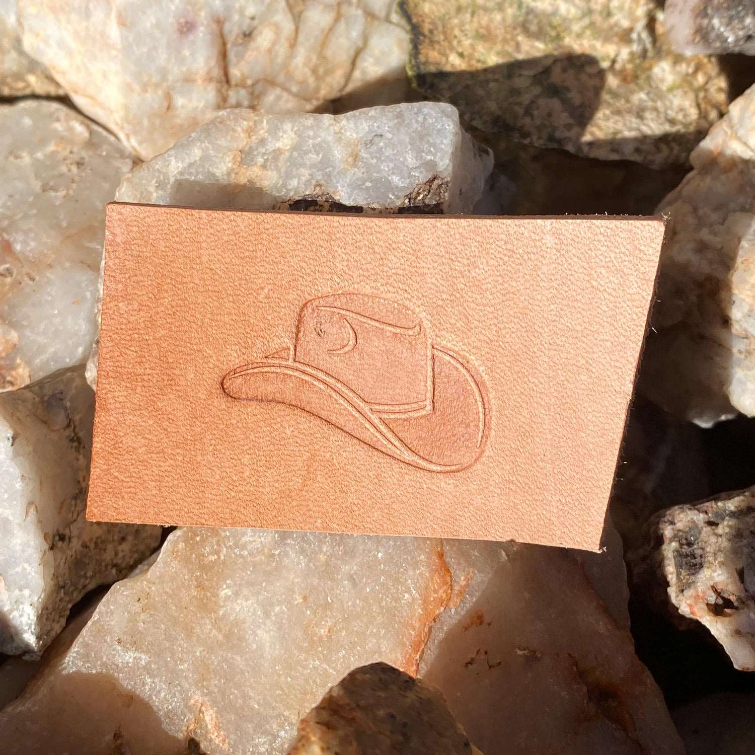 Stamped impression of a classic cowboy hat made with a Delrin leather stamp on natural veg-tan leather.