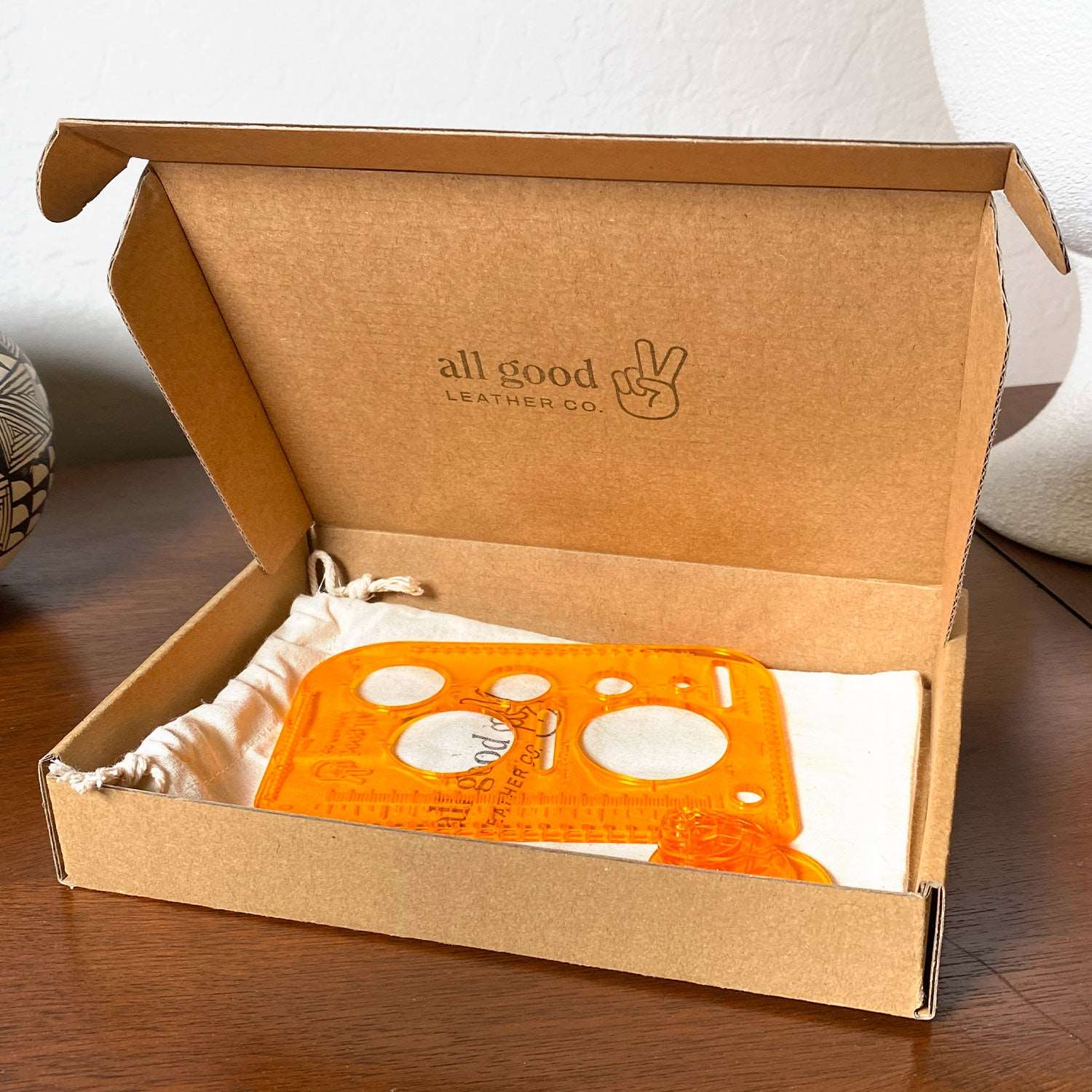 Leatherworking multi-tool packaged in a kraft box with cotton storage bag