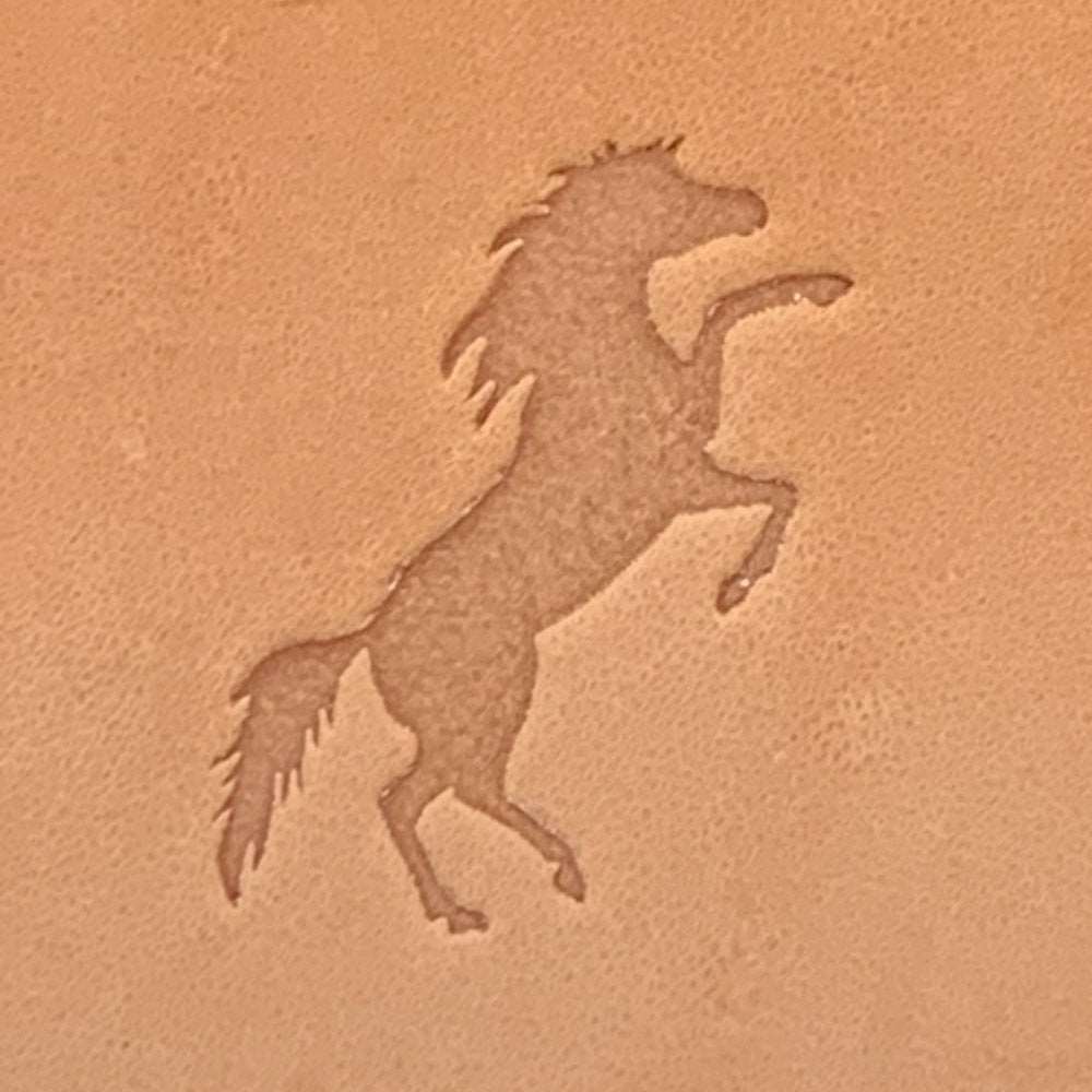 Stamped impression of a rearing horse made with a Delrin leather stamp on natural veg-tan leather.