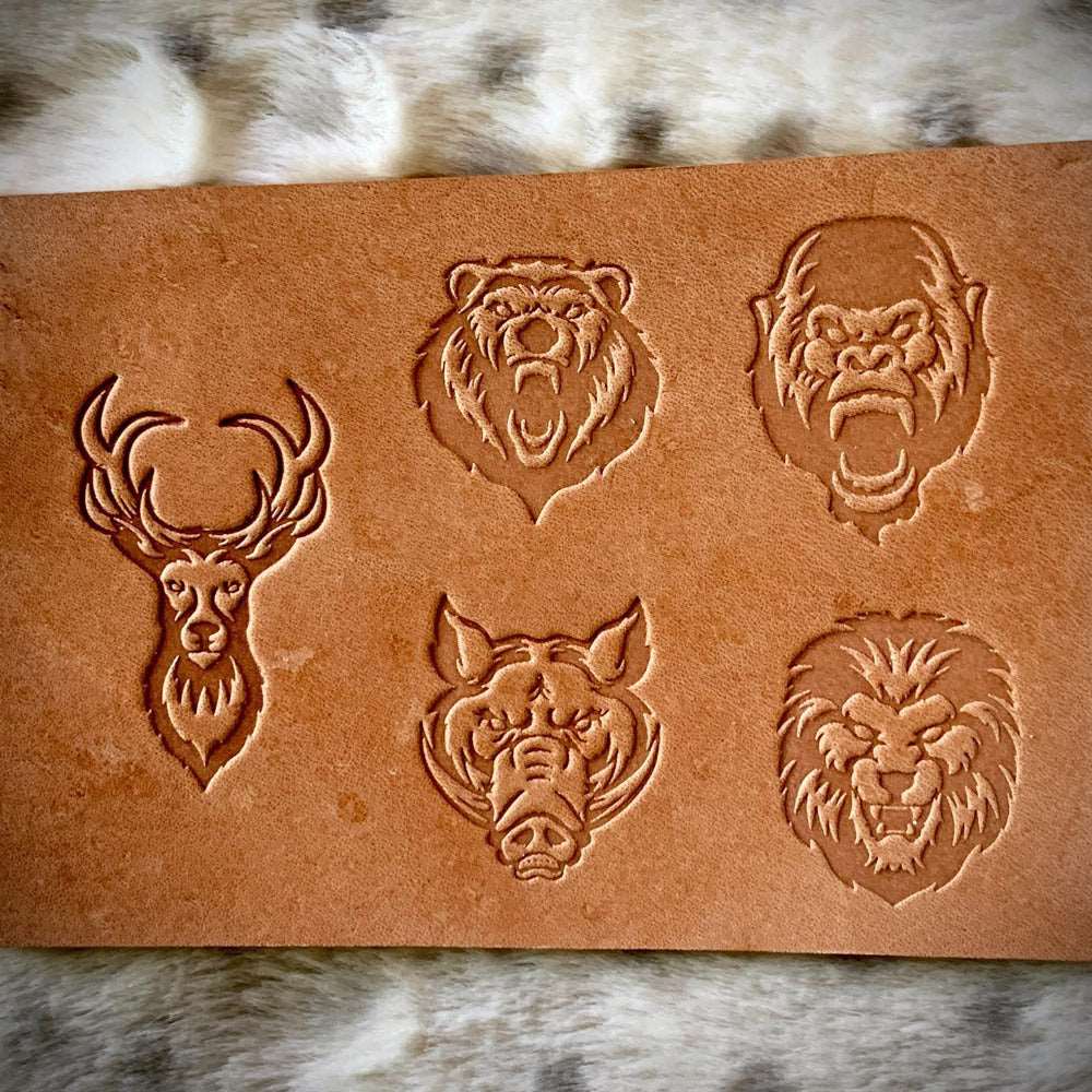 Wild animal head designs stamped into natural veg-tan leather using a Delrin leather stamp, showing deep texture and defined fur details.