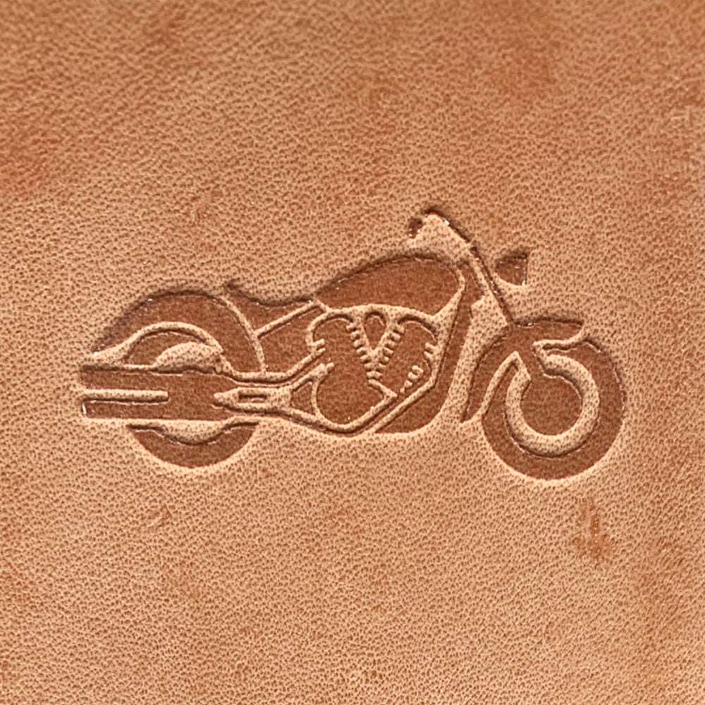 Natural veg-tan leather stamped with a cruiser motorcycle silhouette using a Delrin leather stamp, showing bold shapes and smooth curves.