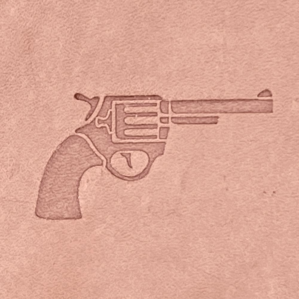 Stamped impression of a classic revolver handgun made with a Delrin leather stamp on natural veg-tan leather.