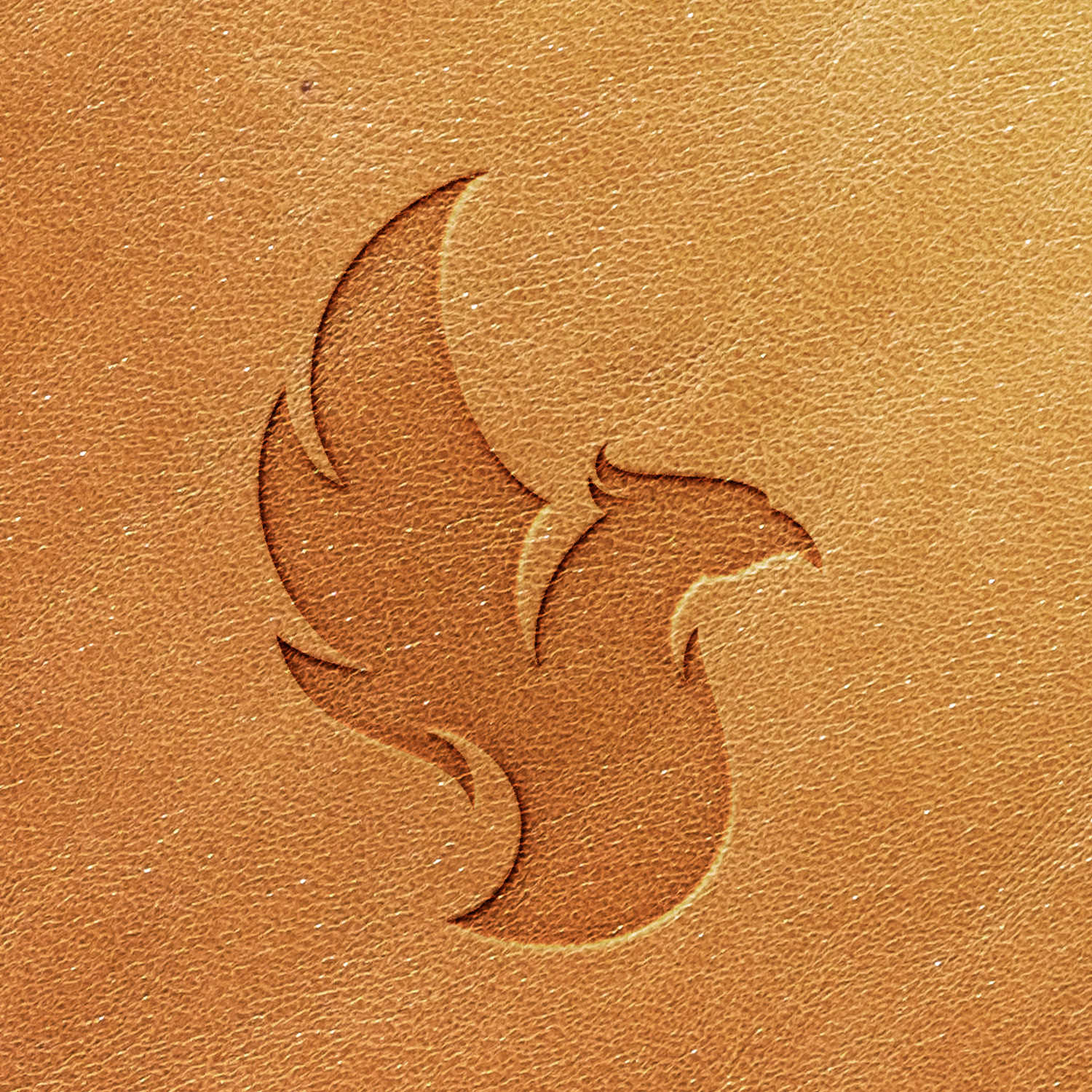 Veg-tan leather stamped with a phoenix design using a Delrin leather stamp, showing a clean, even impression.
