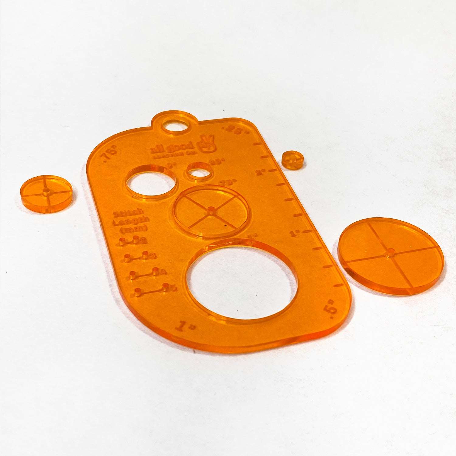 Leatherworking multi-tool with removable circle stencil cutouts showing pilot holes for center marking