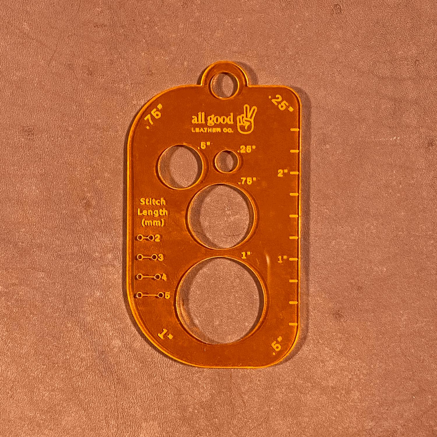 Fluorescent orange leatherworking multi-tool with circle stencils and ruler guides on leather