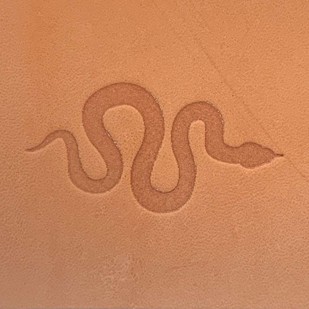 Vegetable-tanned leather stamped with a snake silhouette using a Delrin leather stamp.