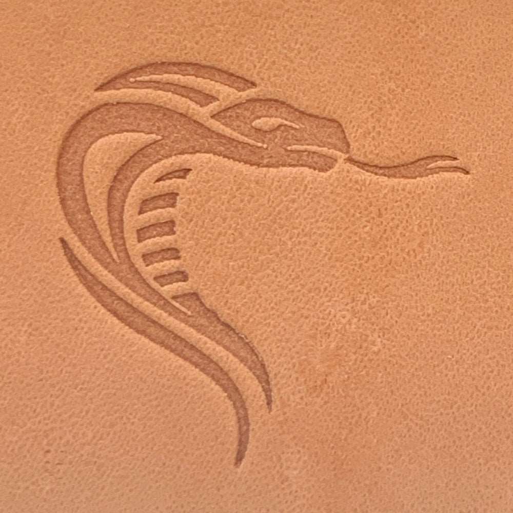 Close-up of vegetable-tanned leather stamped with a snake head design using a Delrin leather stamp.