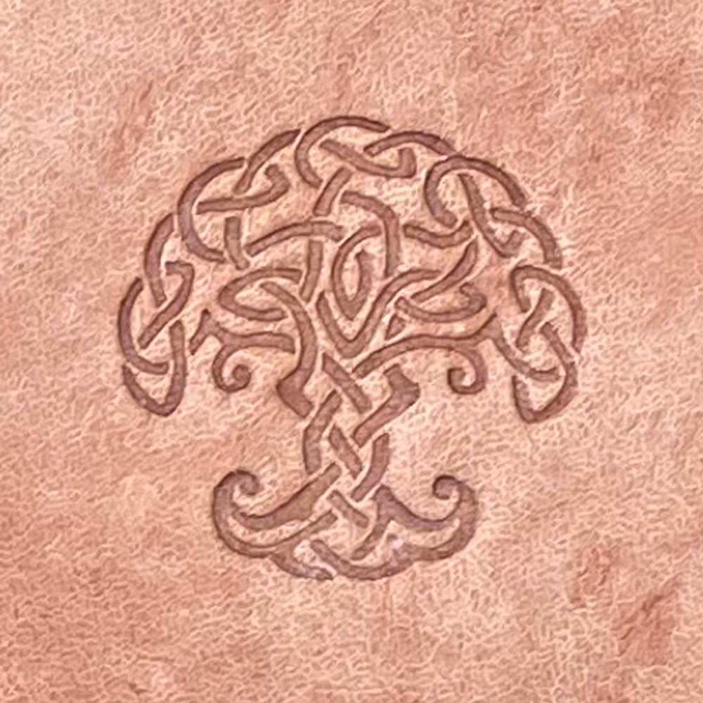 Celtic Tree Delrin Leather Stamp featuring a stone carving of a stylized tree, with an intricate design of looping patterns resembling Celtic knots on a textured brown stone surface.